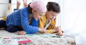 Deux enfants qui s'amusent en regardant et lisant un magazine Picadelo - Box activité créatives et éducatives pour enfants de 3 à 7 ans